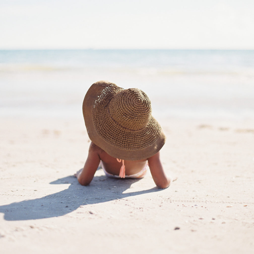 woman traveling alone sunbathing on the beach | wanderful company