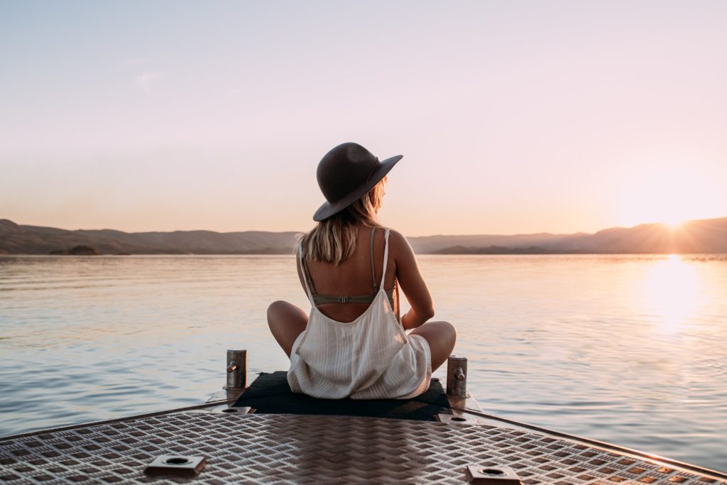 woman solo traveling beside a lake